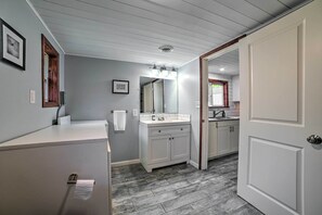 A bathroom with a white vanity, a large mirror, and a sink. - Prudenville Retreat w/ Yard ~ 1 Mi to Lake! (Prudenville)