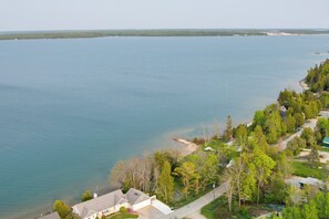 Une vue aérienne d’une propriété au bord du lac, avec des maisons, des arbres et une vue dégagée sur le lac.