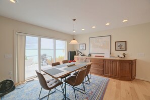 A dining area with a table, chairs, and a view through a glass door. - Lakefront De Tour Village Home w/ Deck & Fire Pit! (De Tour Village)