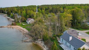 Ett bostadsområde med ett hus vid en sjö, omgivet av träd och en skog.