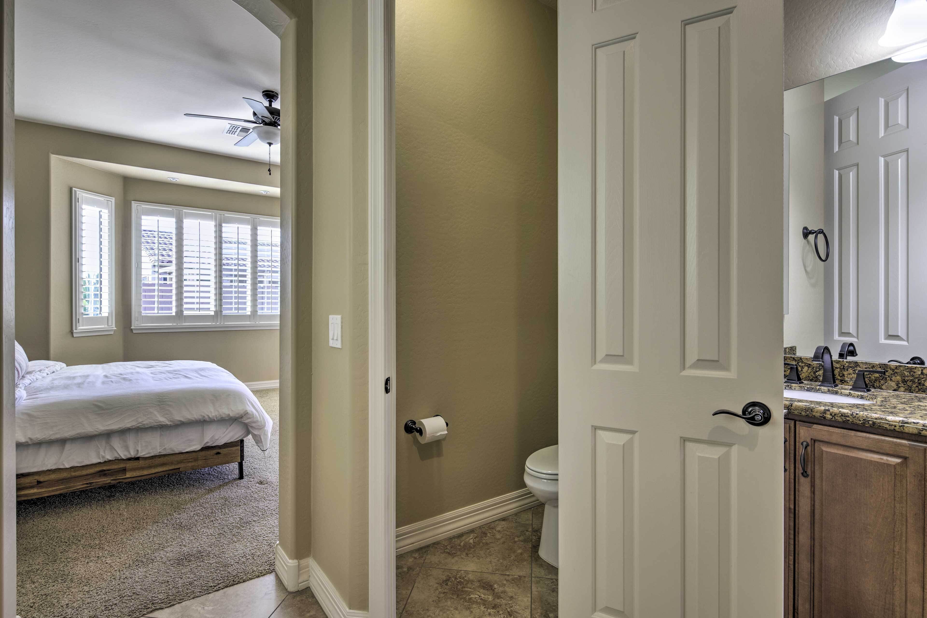 A bedroom with a bed, a ceiling fan, and a window with blinds.