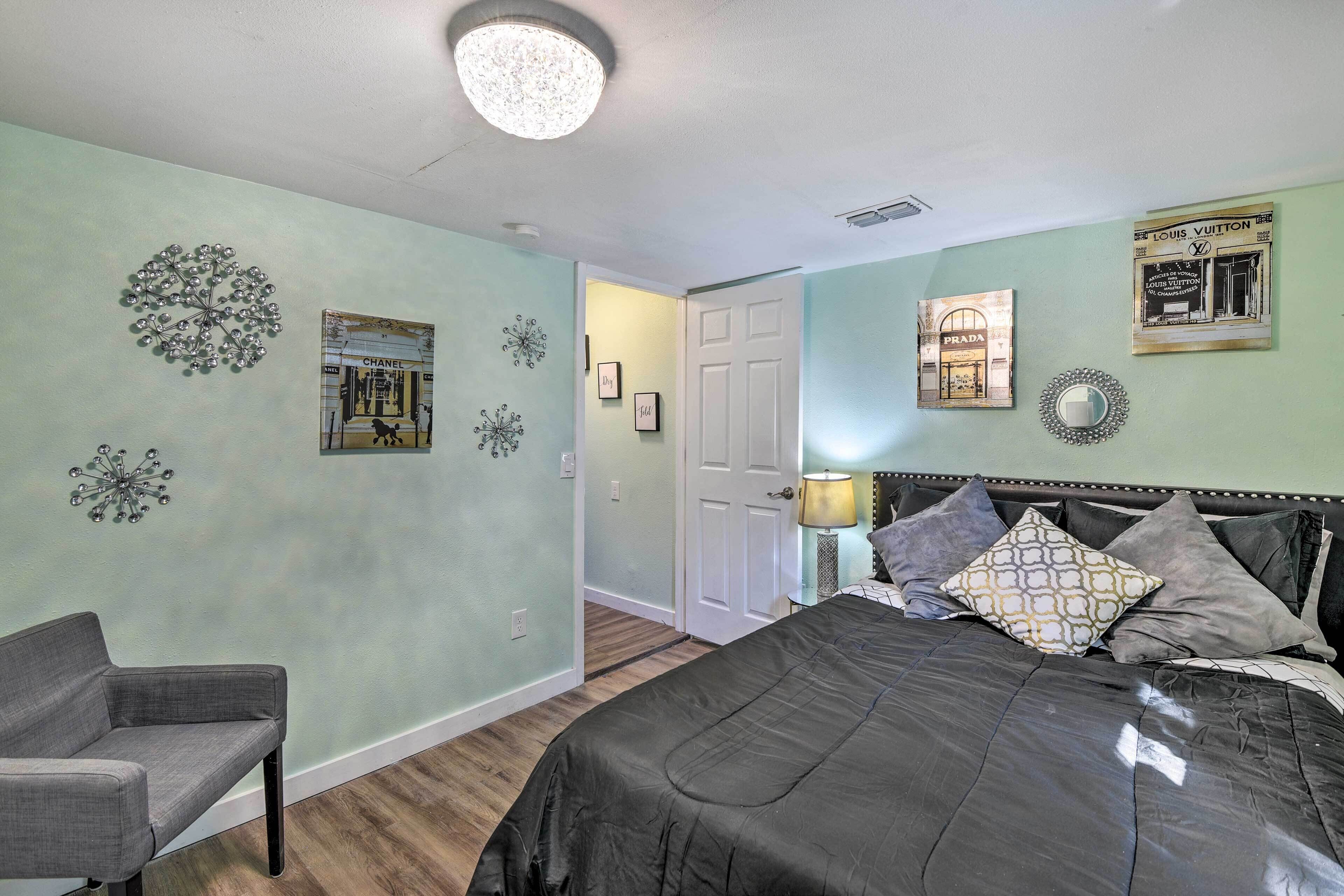 Quarto com cama, uma cadeira e arte decorativa na parede.