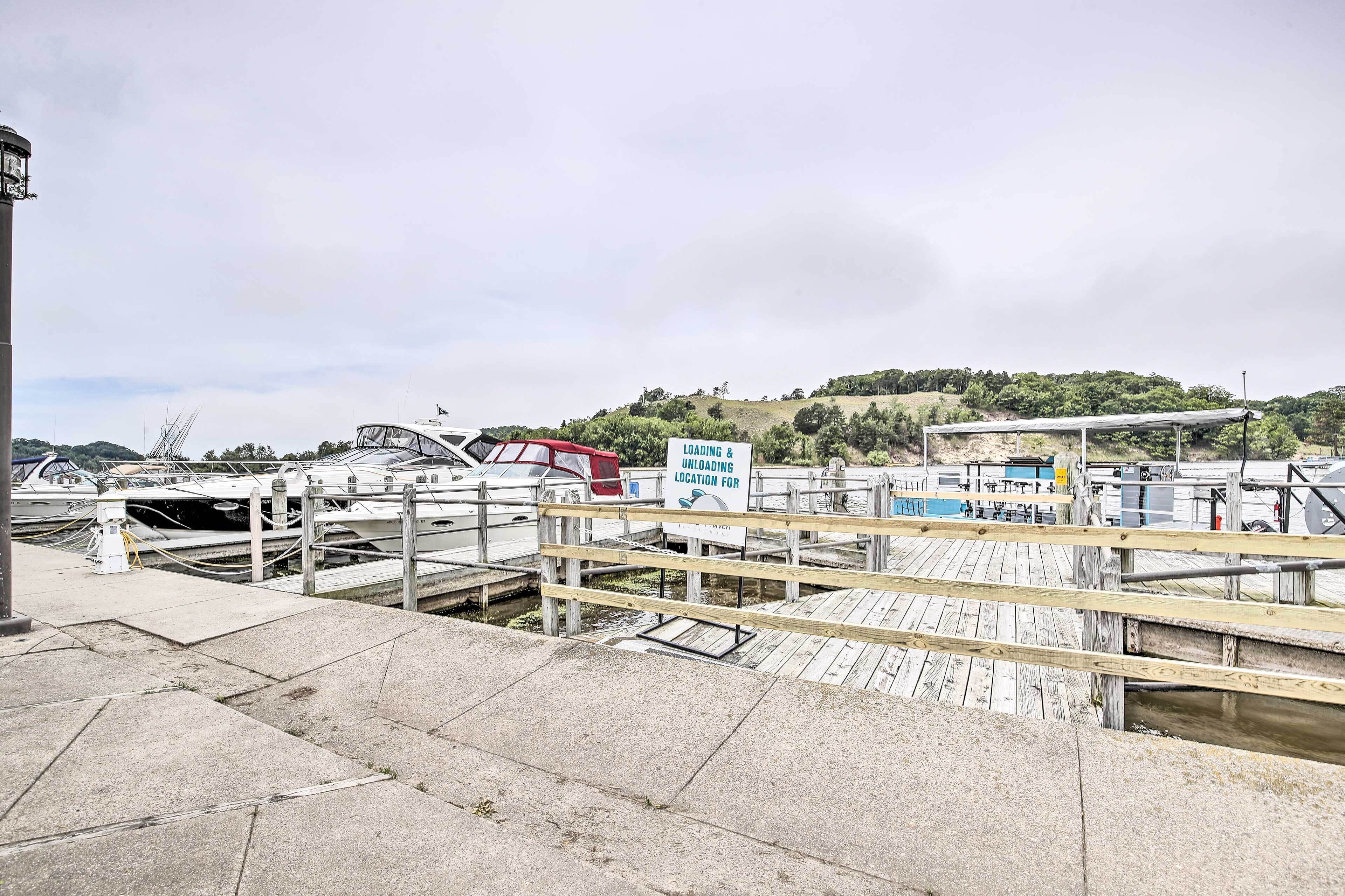 A marina with docked boats, a loading & unloading area, and a wooden walkway.