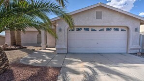 A single-story house with a garage, palm trees, and a stone pillar. - Temp-controlled Pool: Lake Havasu Escape, Mtn View (Lake Havasu City)