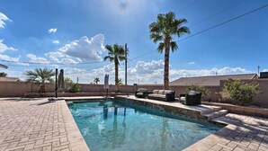 A swimming pool with a brick patio, palm trees, and outdoor furniture. - Temp-controlled Pool: Lake Havasu Escape, Mtn View (Lake Havasu City)