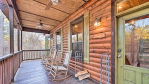 A wooden cabin with a porch featuring rocking chairs and a wooden door. - Broken Bow Cabin w/ Deck, Hot Tub & Fire Pit! (Broken Bow)