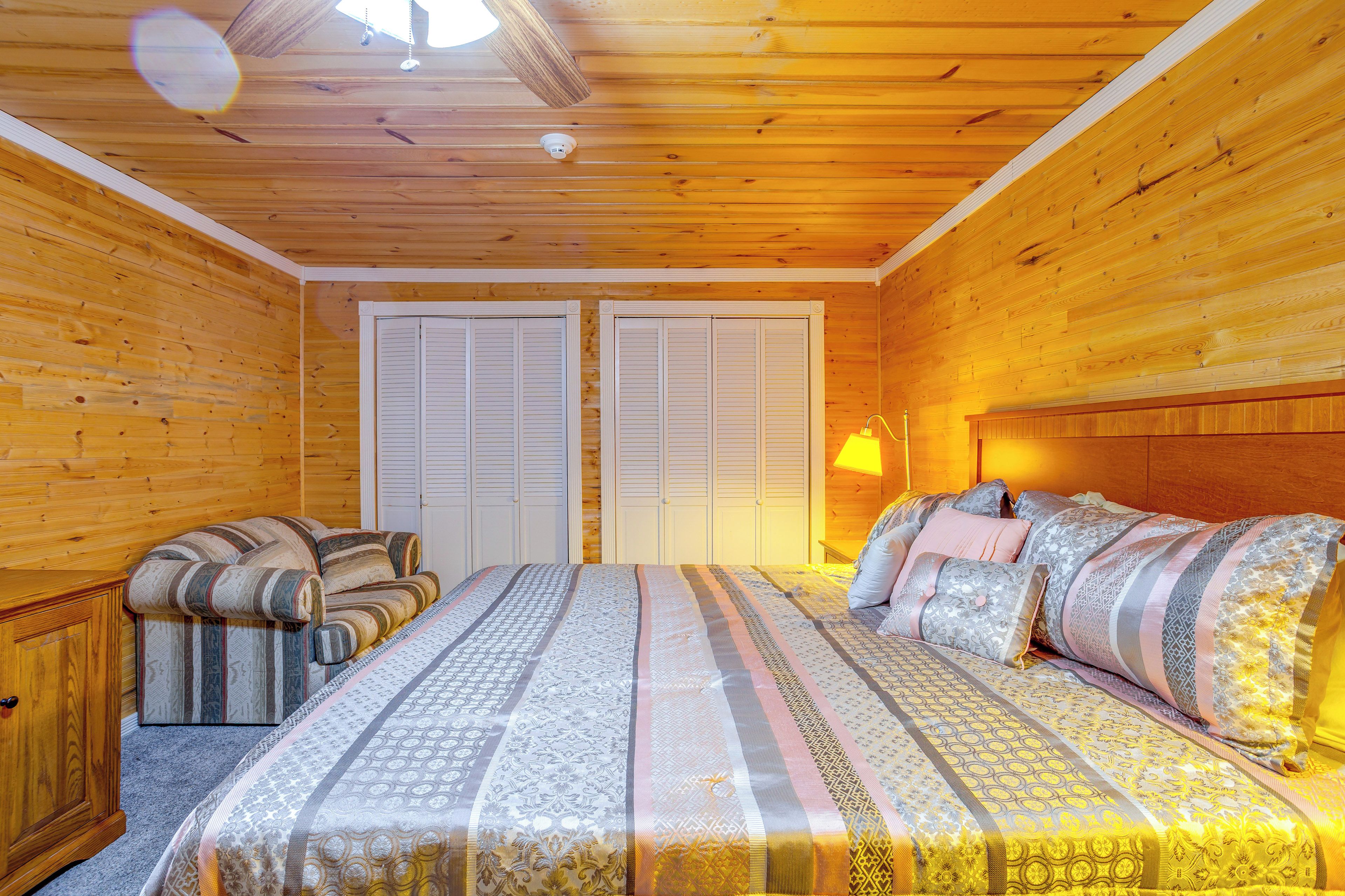 A wooden room with a bed, a sofa, and a wardrobe.
