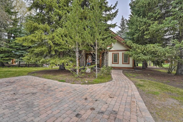 A rustic lodge with a stone facade, a brick pathway leading to the entrance, and a small porch area.