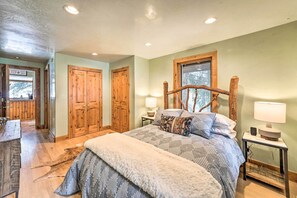 Une chambre avec un grand lit, une armoire en bois et une fenêtre donnant sur un beau paysage.