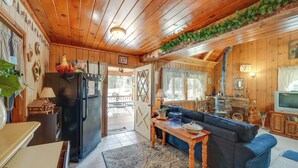 A cozy cabin interior with a wooden ceiling, a dining area with a table and chairs, a living room with a sofa, and a kitchen with a refrigerator and stove. - Mountain Top's Ponderosa Getaway Near Dome Rock! (Springville)