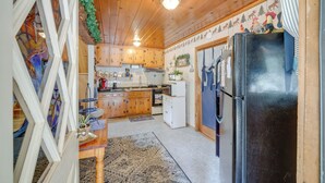 A kitchen with wooden cabinets, a refrigerator, and a stove. - Mountain Top's Ponderosa Getaway Near Dome Rock! (Springville)