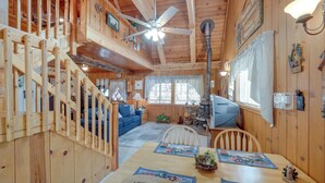 A wooden cabin interior with a dining area, staircase, and a ceiling fan. - Mountain Top's Ponderosa Getaway Near Dome Rock! (Springville)