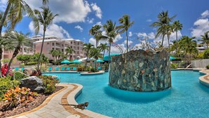 A resort pool with palm trees, a stone fountain, and a building in the background. - Tropical St. Thomas Resort Getaway w/ Pool Access! (St. Thomas)