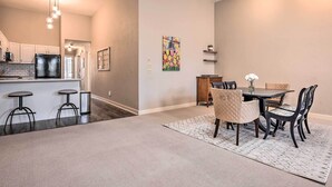 A spacious living area with a dining table and chairs, a kitchen with white cabinets, and a hanging light fixture. - Charming Dtwn Holland Escape: Above Crust 54! (Holland)