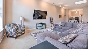 A modern living room with a grey sofa, a patterned armchair, and a black coffee table. - Charming Dtwn Holland Escape: Above Crust 54! (Holland)