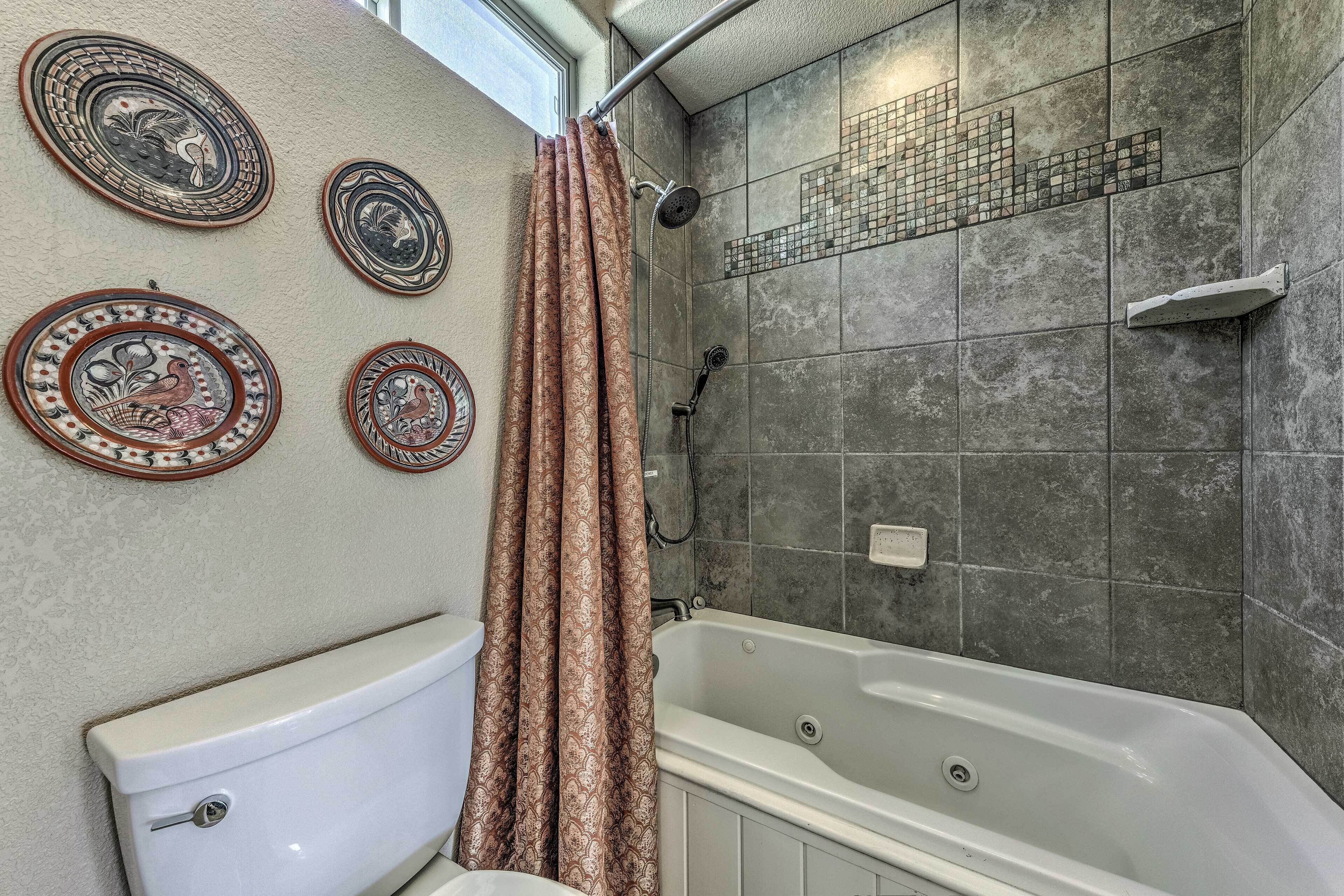 Une salle de bain équipée de toilettes, d’une douche et d’une baignoire.
