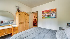 Un dormitorio con una cama grande, un armario de madera y un cuadro en la pared.