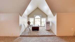A room with a sloped ceiling, a window, a chair, a table, and a heater. - 'the Diamond Bungalow' - Cozy Caldwell Home! (Caldwell)