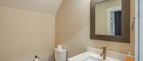 Ein Badezimmer mit Toilette, Waschbecken und Spiegel.