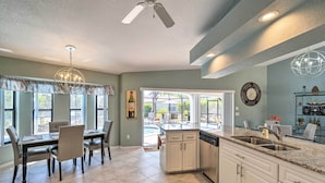 A spacious kitchen with a dining area, large windows, and a view of the backyard. - Modern House < 5 Miles to Port Charlotte Beach! (Port Charlotte)