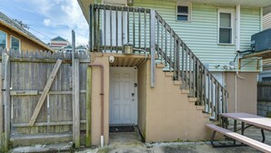 A residential property with a wooden fence, a concrete driveway, a front door, and a picnic table. - Seaside Heights Apt < 2 Blocks to Boardwalk! (Seaside Heights)