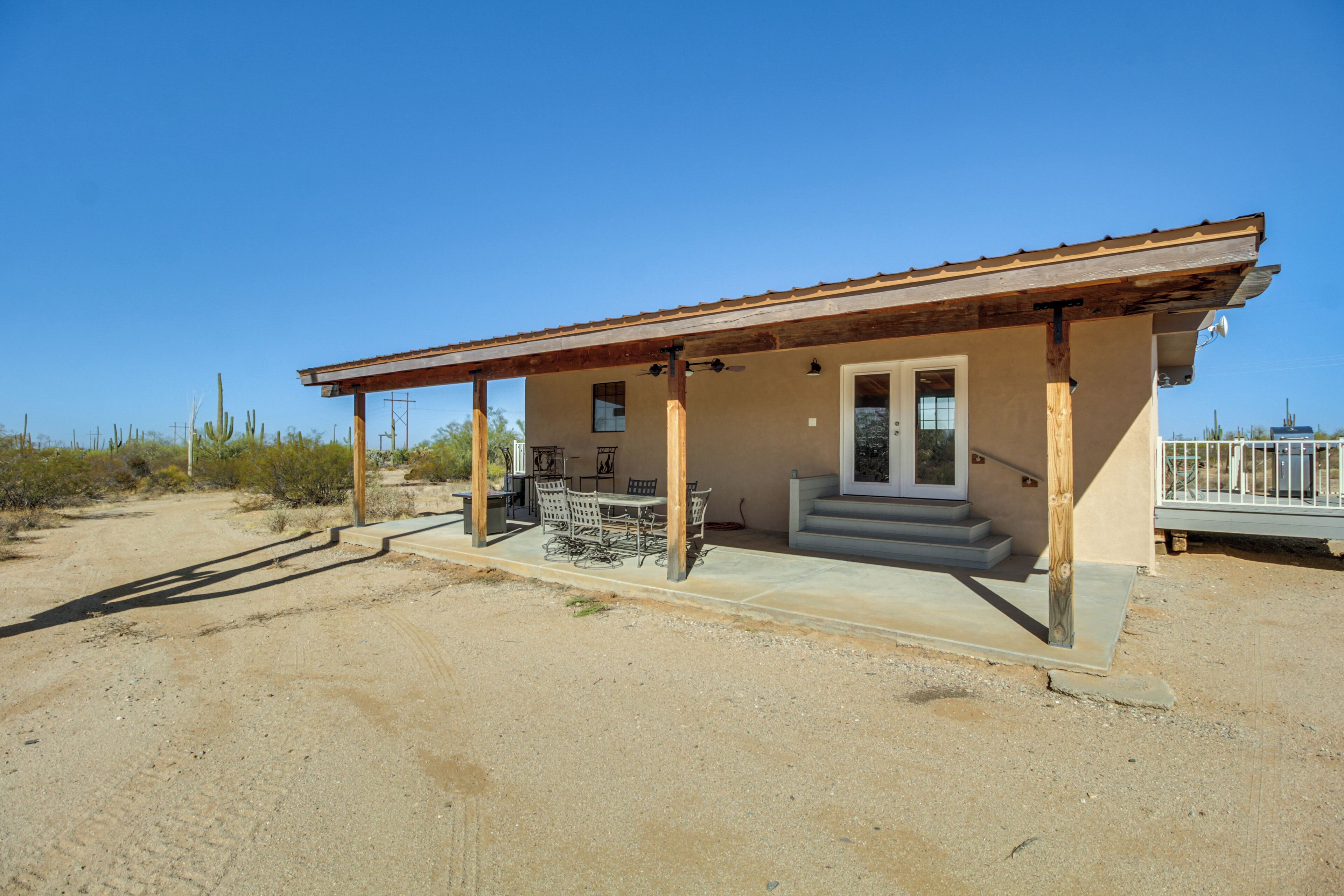A single-story building with a covered patio, a small porch, and a door leading to a garage.
