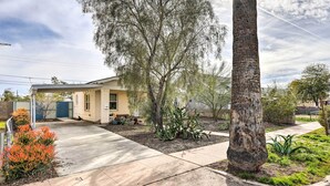 Ein Wohnhaus mit überdachter Terrasse, einem Bungalow und einem angelegten Garten mit Kakteen und Sträuchern.