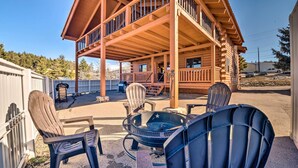 Une cabane en bois dotée d’un patio couvert, de meubles d’extérieur et d’un foyer.