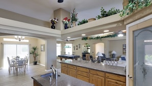 A spacious kitchen with granite countertops, wooden cabinets, and a central island. - Infinity Pool & Lake Views: Havasu Group Escape (Lake Havasu City)