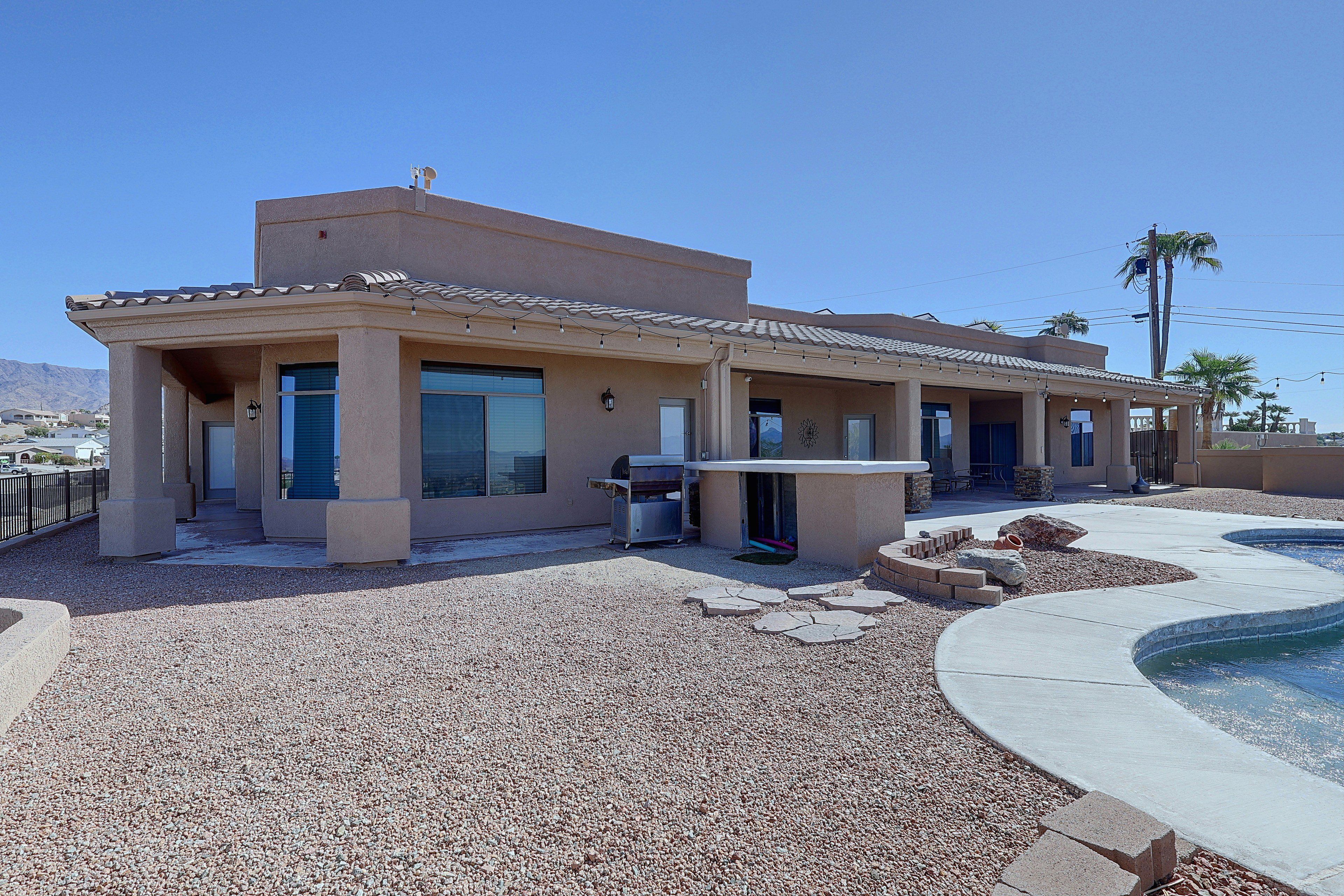 A residential building with a patio area, outdoor seating, and a swimming pool.