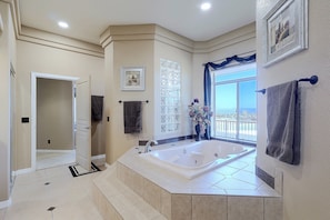 Un baño con una bañera grande, una ducha y una ventana con vistas.