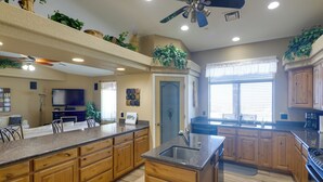 A spacious kitchen with wooden cabinets, a granite countertop, and a built-in island. - Infinity Pool & Lake Views: Havasu Group Escape (Lake Havasu City)