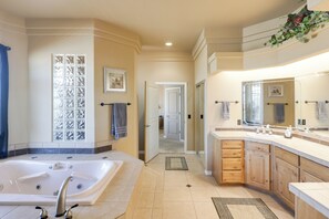 Une salle de bain moderne avec une grande baignoire, des meubles en bois et une douche à l’italienne.