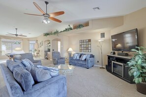 A spacious living room with a ceiling fan, a flat-screen TV, and a fireplace. - Infinity Pool & Lake Views: Havasu Group Escape (Lake Havasu City)