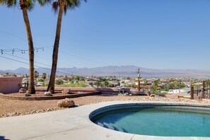 Une piscine offrant une vue sur les montagnes, les palmiers et un quartier résidentiel.