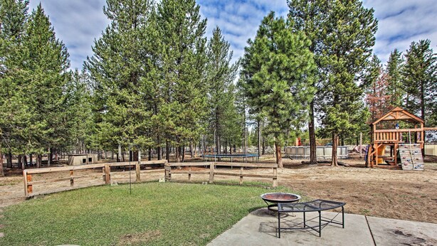 A fenced outdoor area with a picnic table and a play structure. - La Pine Hideaway Near Deschutes National Forest! (La Pine)