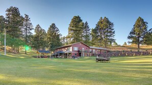 A large building with a red facade, surrounded by a well-maintained lawn and tall trees. - Hill City Hideaway Near Mt Rushmore & Hiking (Hill City)