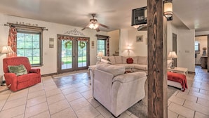 A spacious living room with a ceiling fan, a red armchair, a white sectional sofa, and a wooden pillar with wall sconces. - Valley Cloudcroft Hideaway < 8 Mi to Town! (Cloudcroft)