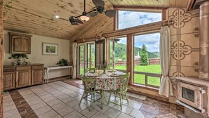 A spacious kitchen with a dining table, wooden cabinets, and a large window offering a view of the outdoors. - Valley Cloudcroft Hideaway < 8 Mi to Town! (Cloudcroft)