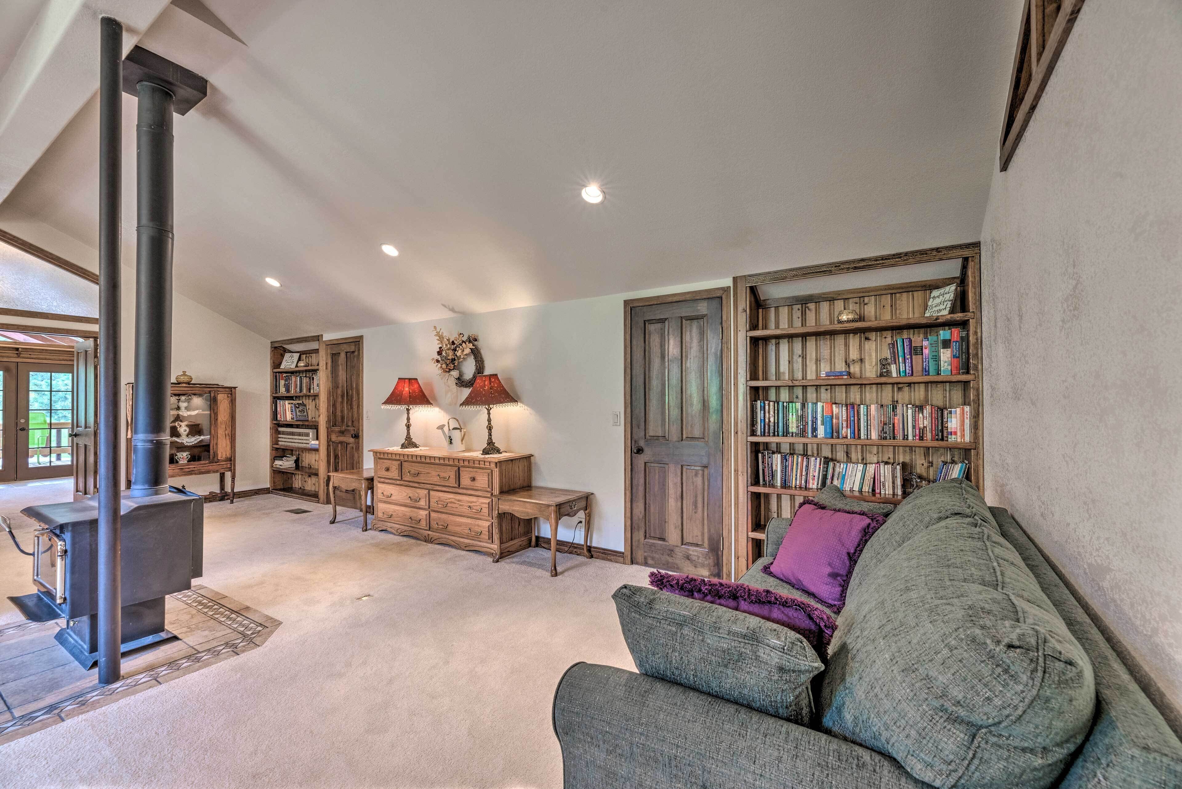 A cozy living room with a fireplace, a bookshelf, and a comfortable seating area.