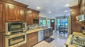 Una cucina moderna con elettrodomestici in acciaio inossidabile, mobili in legno e una grande isola.