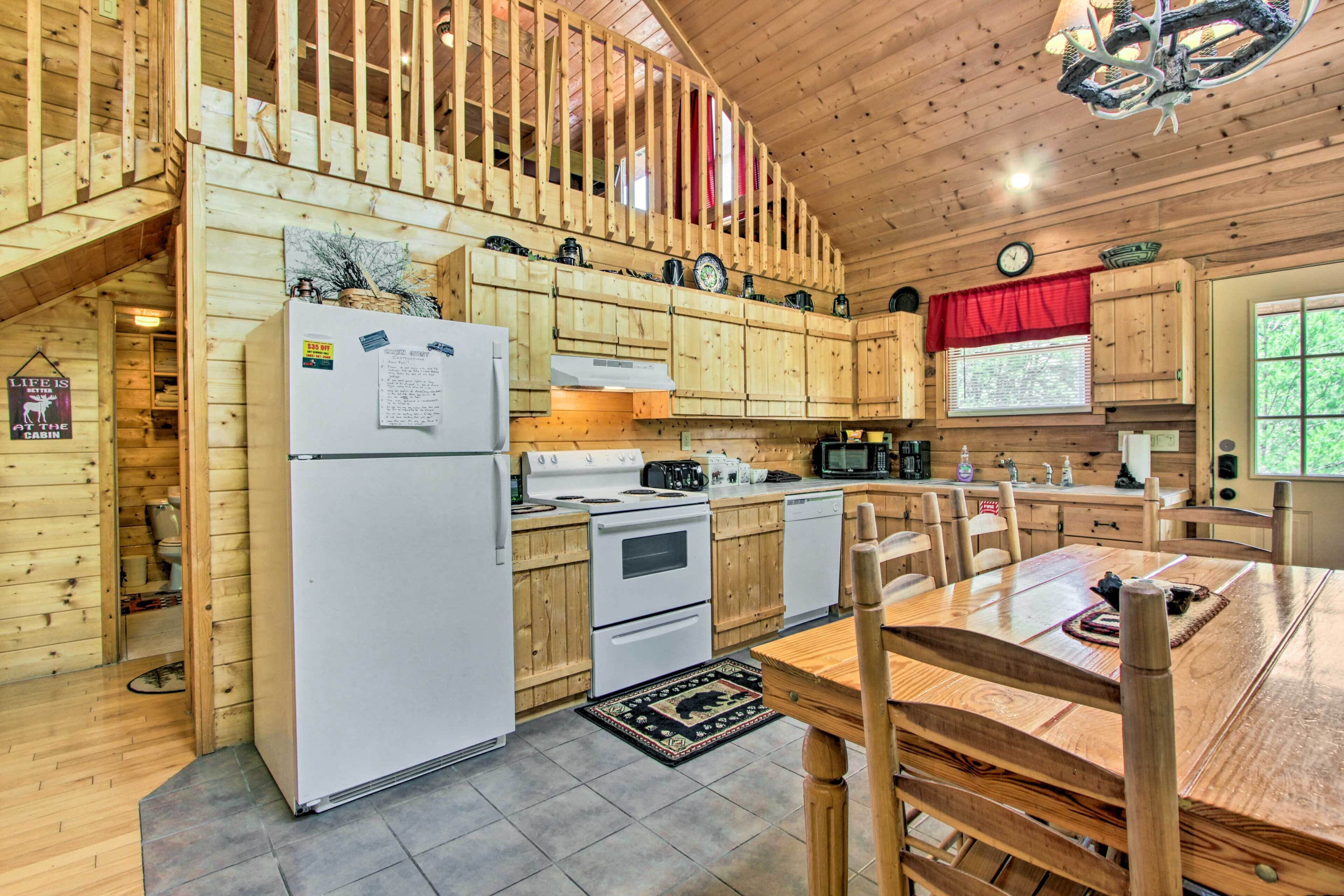 A cabin-style kitchen with wooden walls and a dining area.