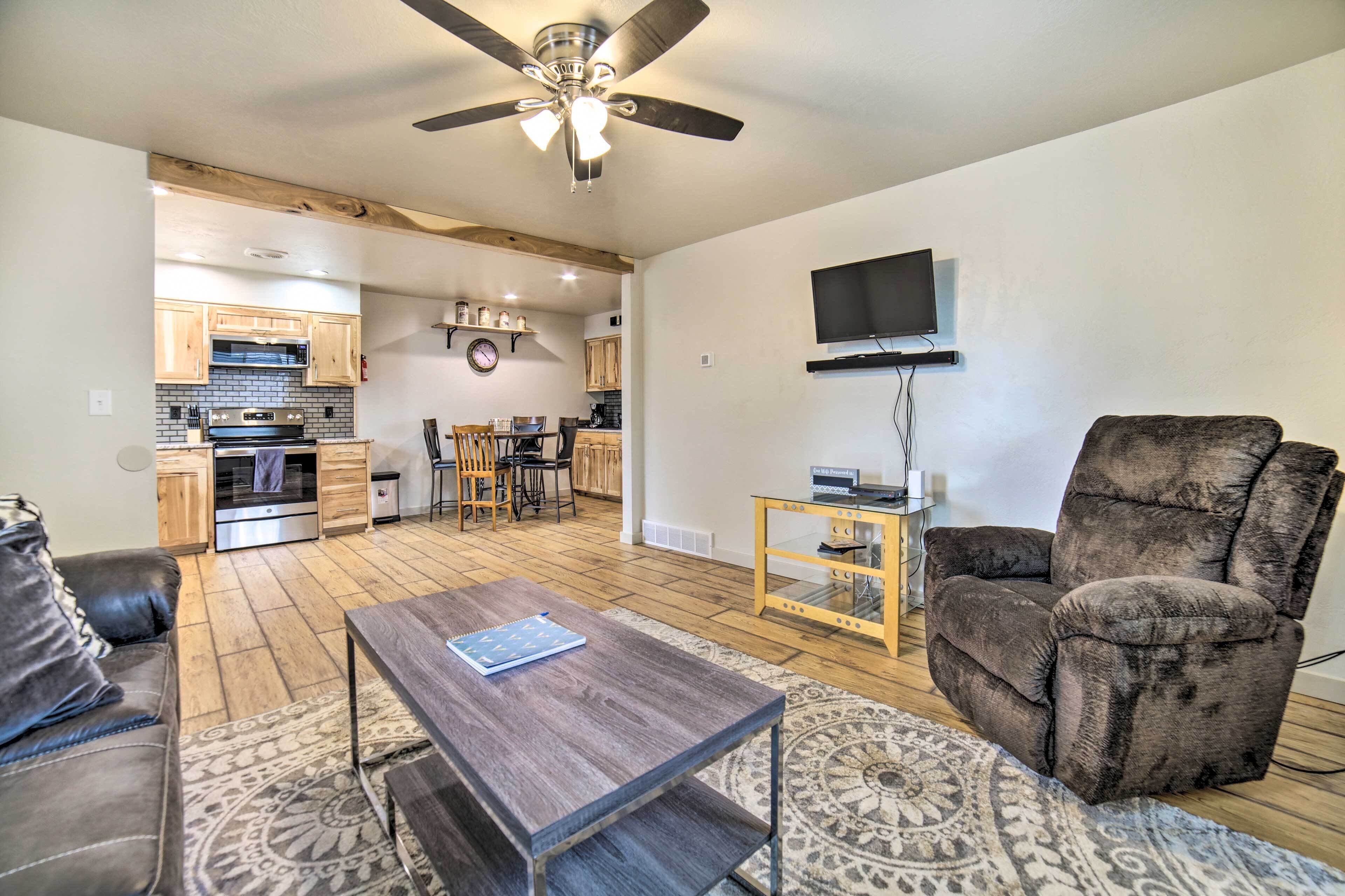 A living room with a sofa, a coffee table, a TV, and a ceiling fan.