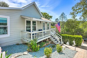 A house with a porch, a flag, and a garden. - Walk to Main St: Historic Cottage in Sutter Creek (Sutter Creek)