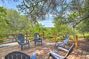 A wooden deck with Adirondack chairs and a view of a lake. - Walk to Main St: Historic Cottage in Sutter Creek (Sutter Creek)