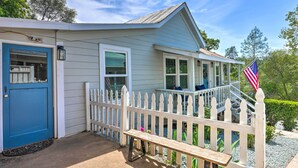 A house with a blue door, white picket fence, and an American flag.