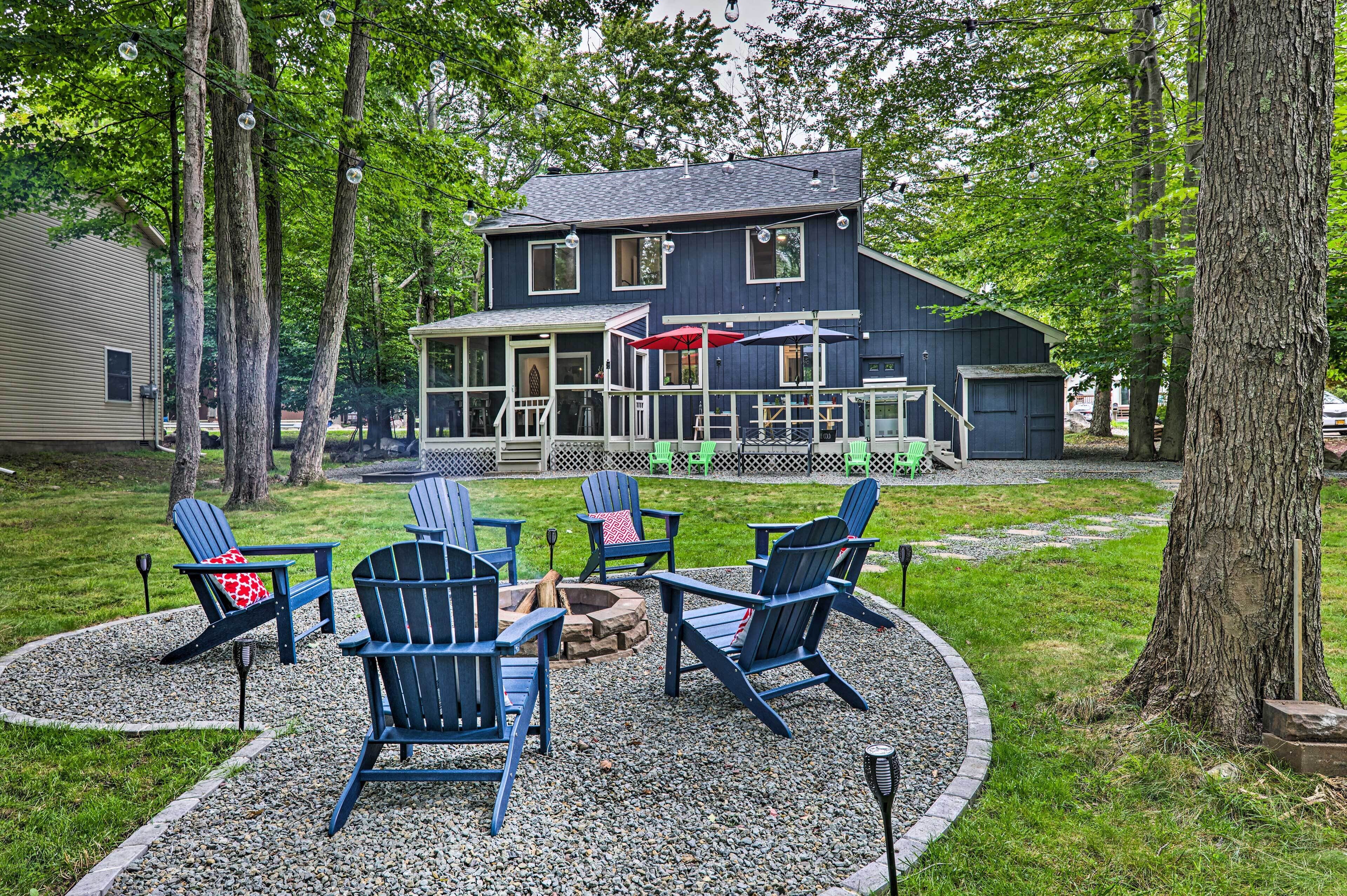 A house with a deck, outdoor seating, and a fire pit.