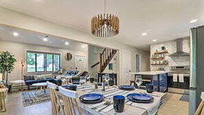A modern kitchen with a dining area, featuring a central island, built-in oven, and a staircase leading to an upper level. - Relax Fireside! Retreat 15 Mi to Camelback Slopes (Tobyhanna)