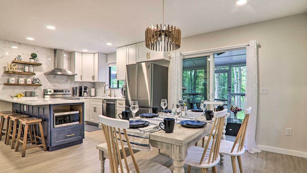 A modern kitchen with a dining area, featuring a central island, wooden chairs, and a chandelier. - Relax Fireside! Retreat 15 Mi to Camelback Slopes (Tobyhanna)