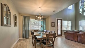 A dining area with a wooden table and chairs, a chandelier, and a leather couch in the background. - Family Home w/ Deck, 3 Mi to Downtown Flagstaff! (Flagstaff)